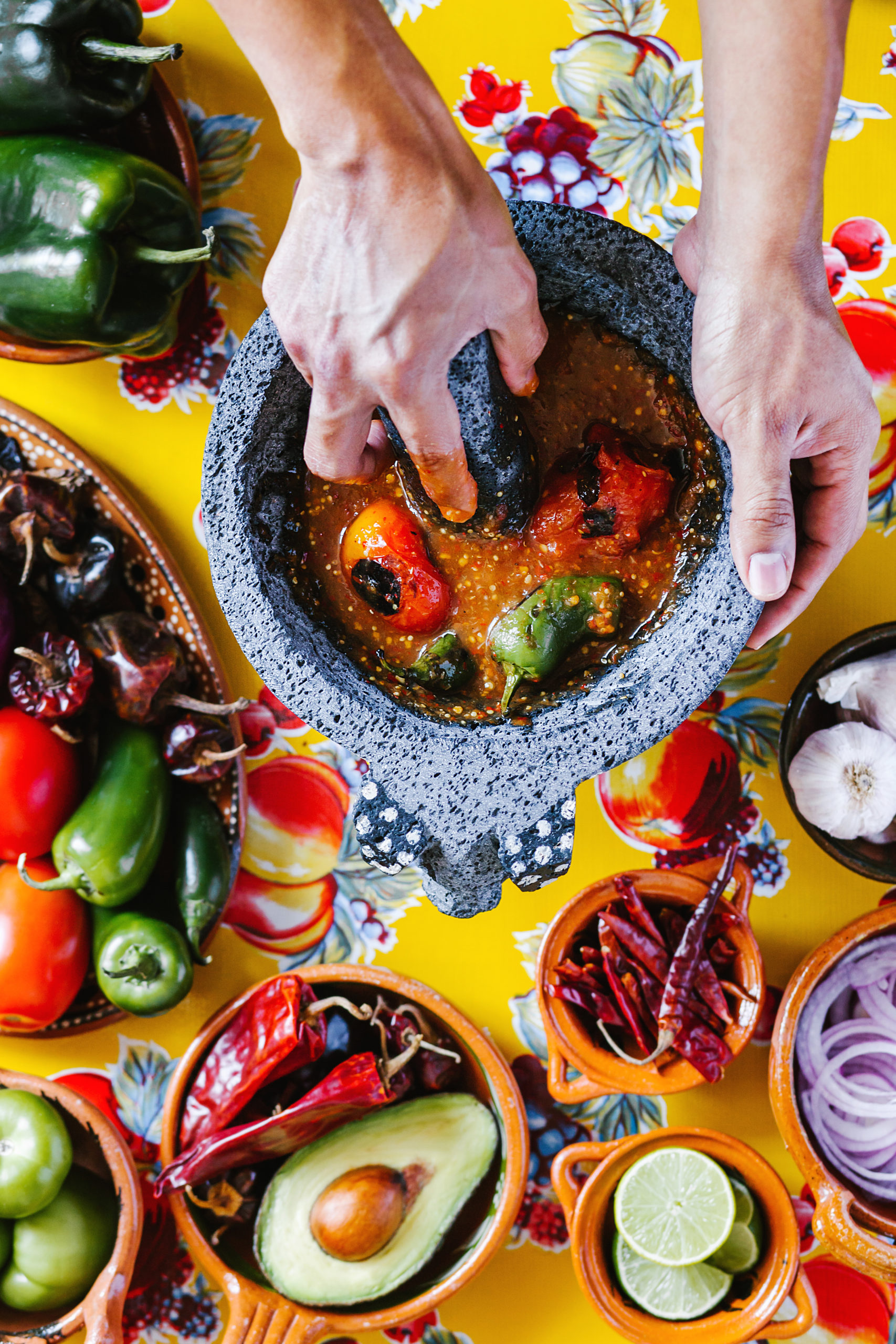 Mexican red sauce in a traditional molcajete and ingredients in kitchen in Mexico city